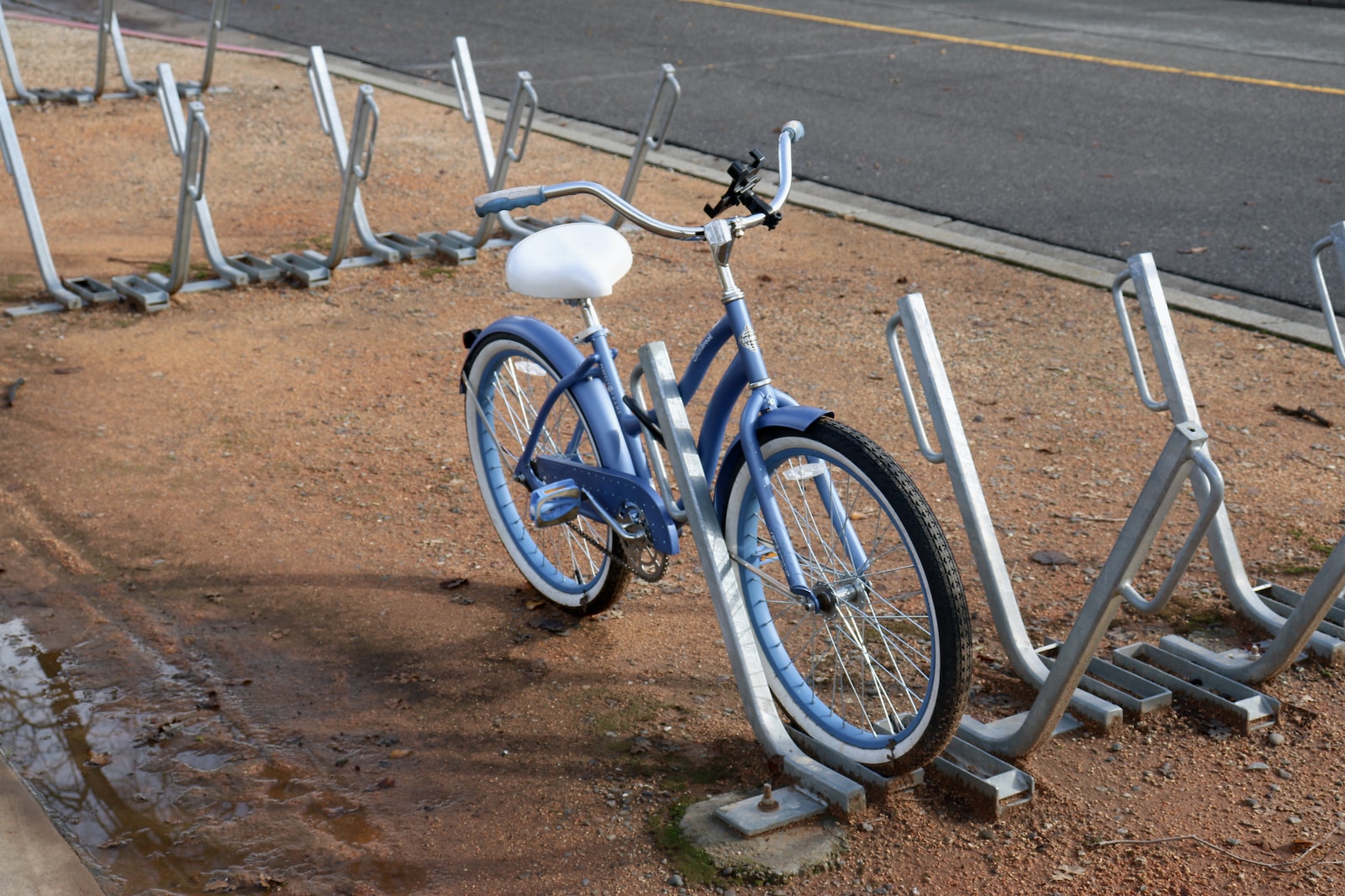 a blue bike parked next to a row of metal bars